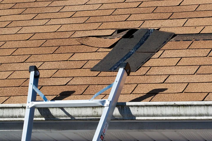 Damaged shingle roof being repaired